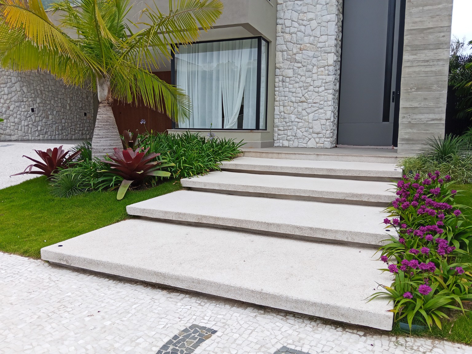Palmeira e vegetação tropical junto à entrada