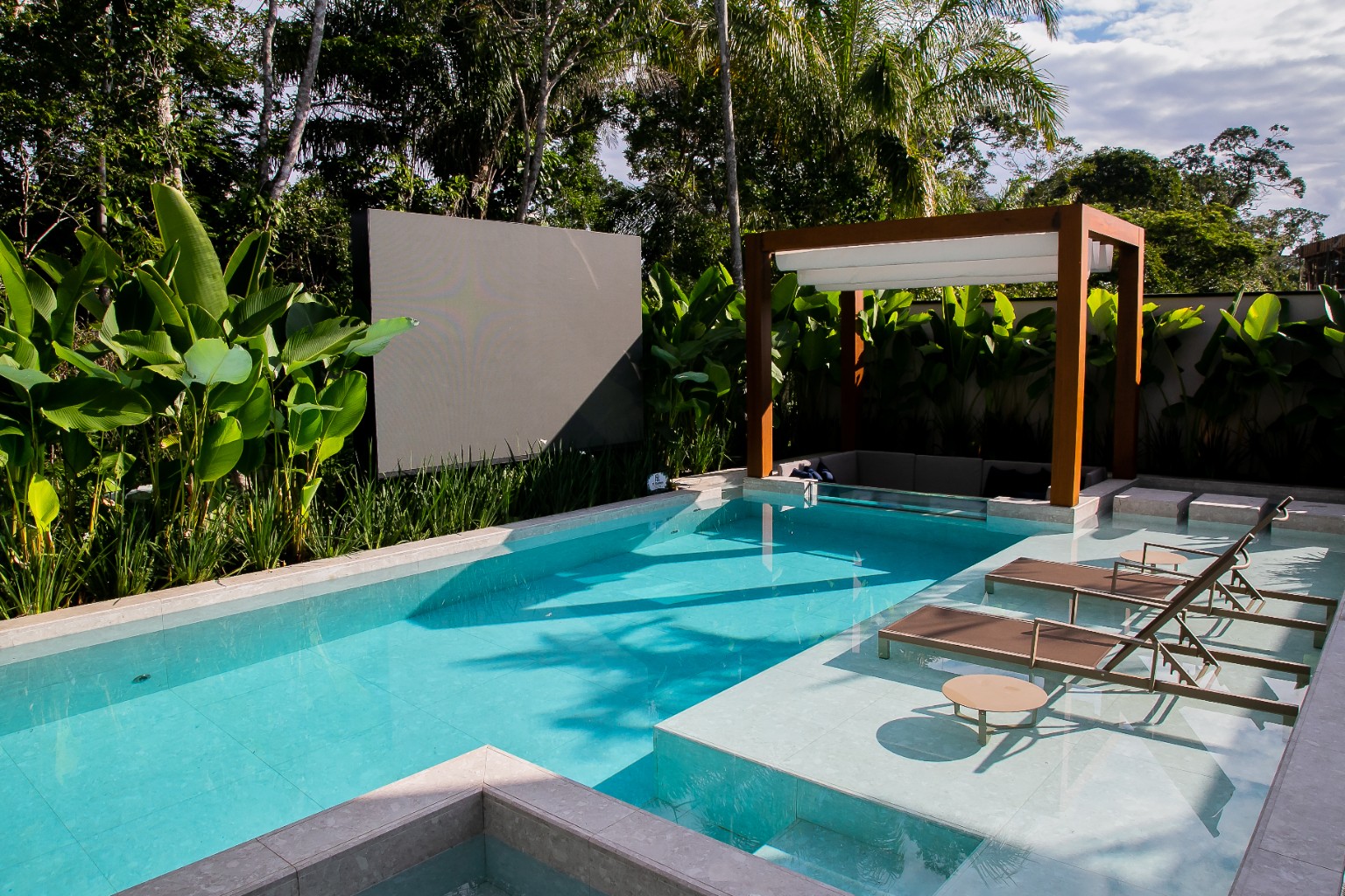 Área de piscina com paisagismo tropical no Módulo 15